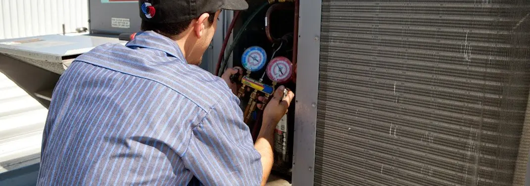 HVAC technician servicing a condenser unit in Haddon Heights